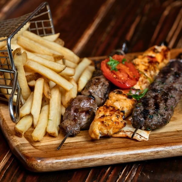 Sirocco Mediterranean Restaurant's mixed grill platter with fries, chicken, beef, and kafta skewers.