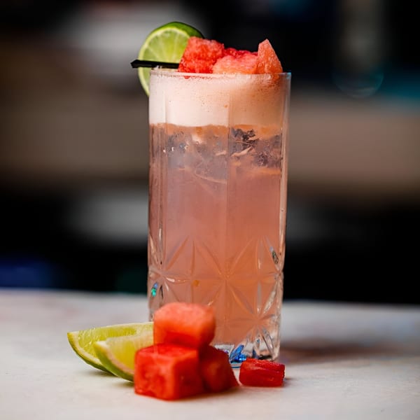 A refreshing Sirocco Mediterranean Restaurant & Lounge watermelon cocktail with lime and watermelon cubes.